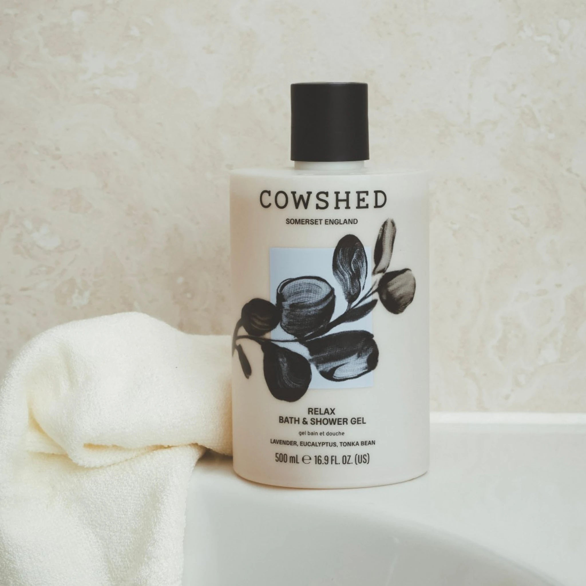Cowshed Relax bath and shower gel 500ml bottle on a textured surface with a towel.