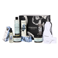 Cowshed skincare products including bottles, jars, and a pouch on a white background