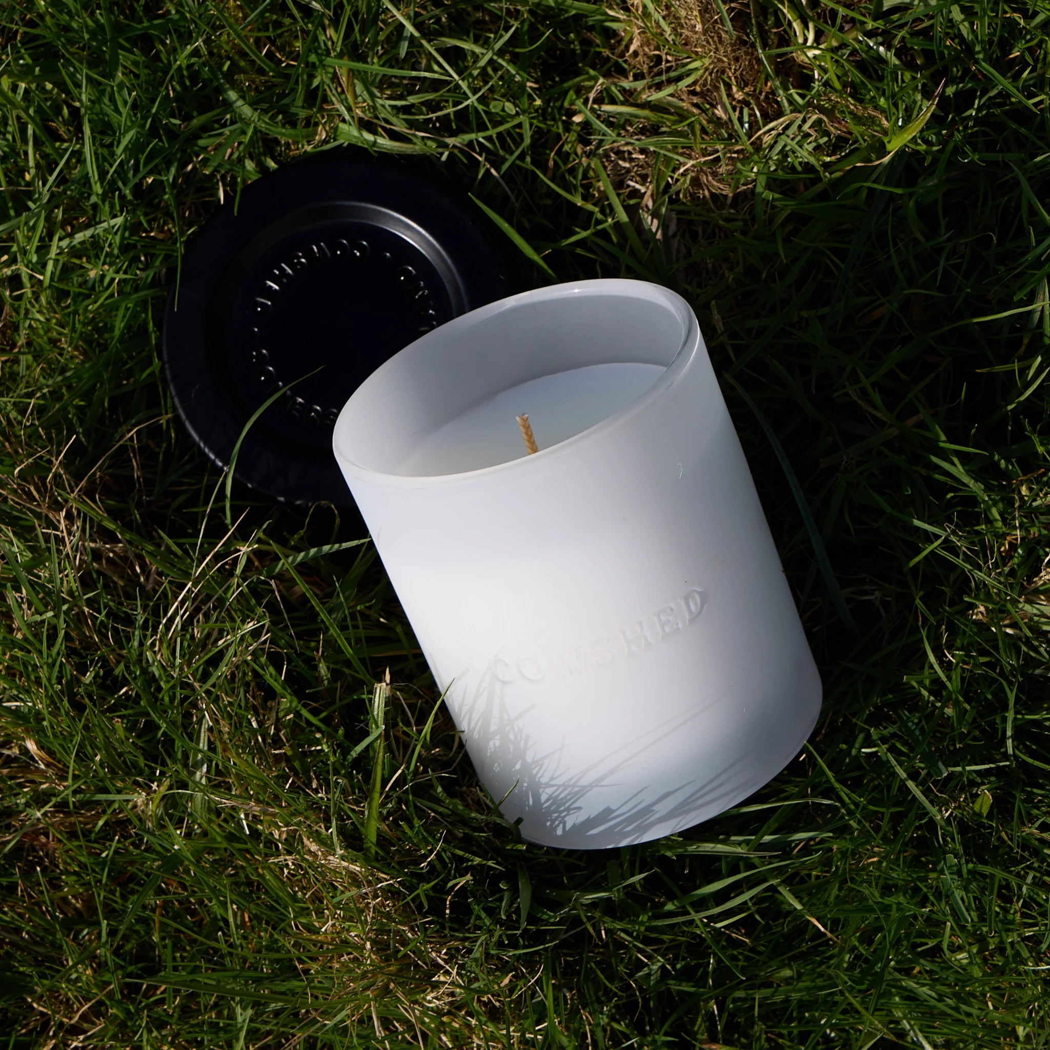 White silicone cup with a lid on grass