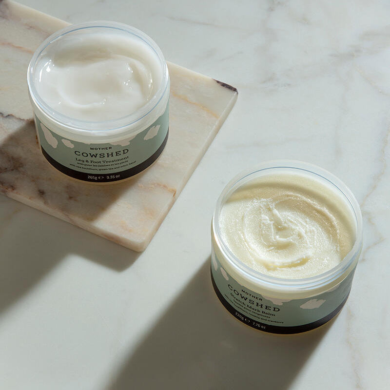 Two jars of Mother Cowshed cream on a marble surface