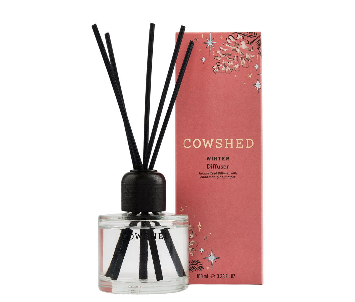 Cowshed Winter Diffuser with a clear glass bottle, black reeds, and a pink decorative box on a white background.