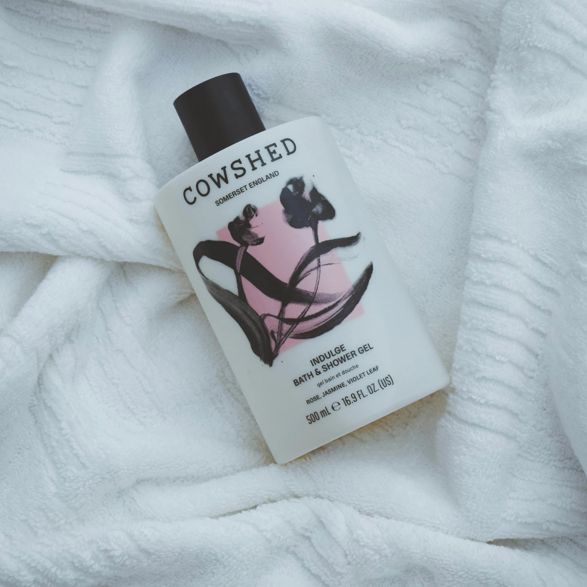 Cowshed bottle of Indulge bath and shower gel 500ml on a white textured surface