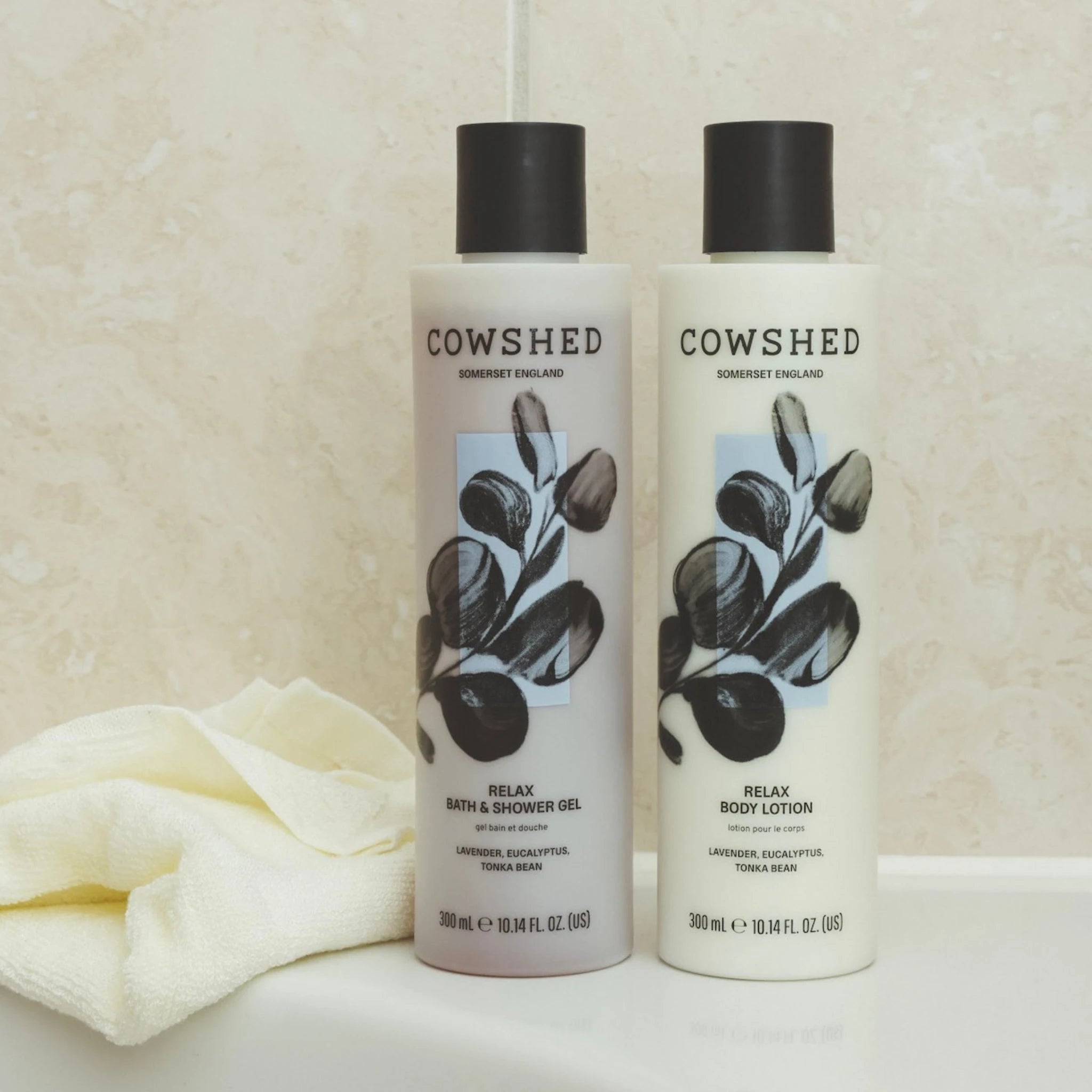 Two Cowshed bath and shower gel bottles on a beige background