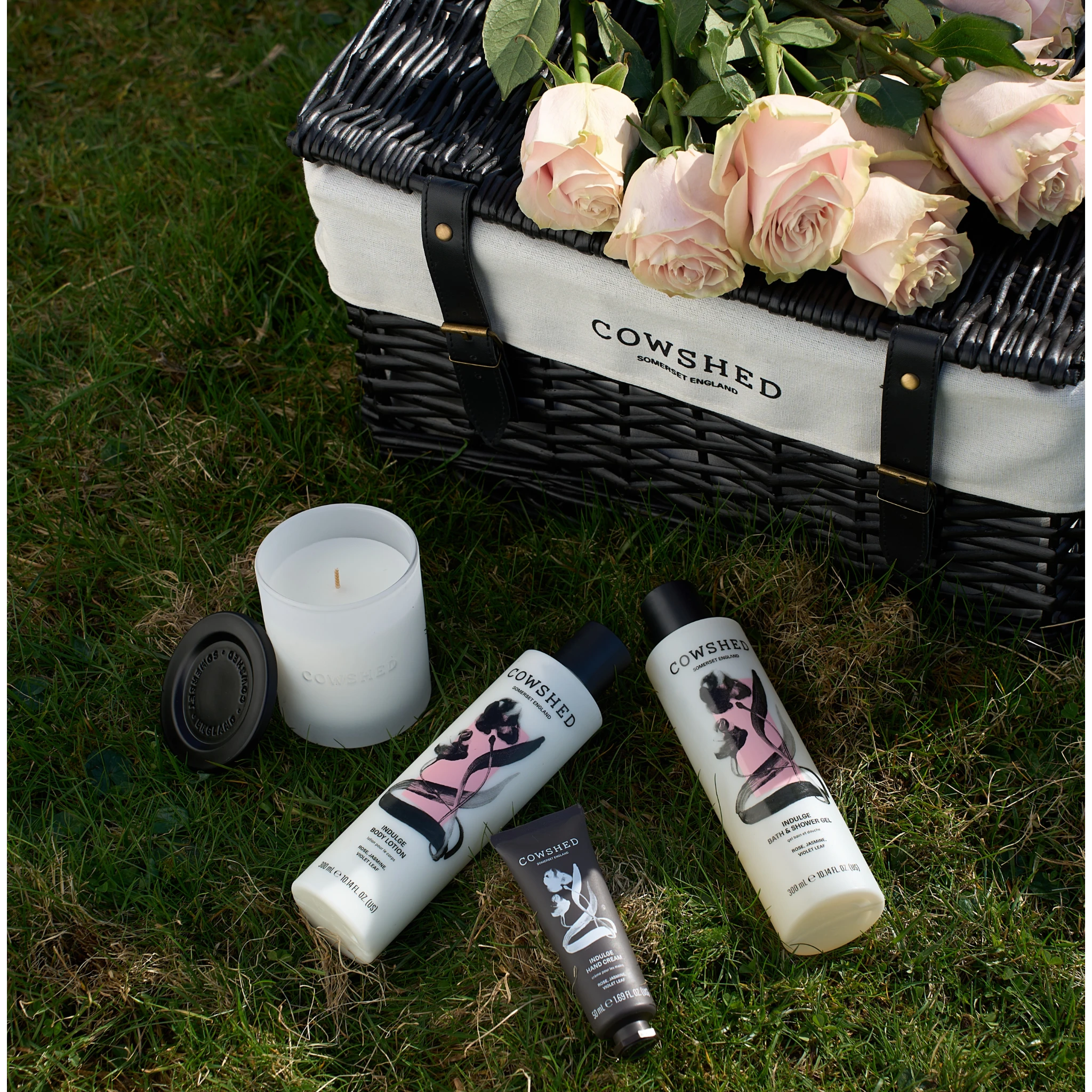 Cowshed product set with a picnic basket and flowers on grass