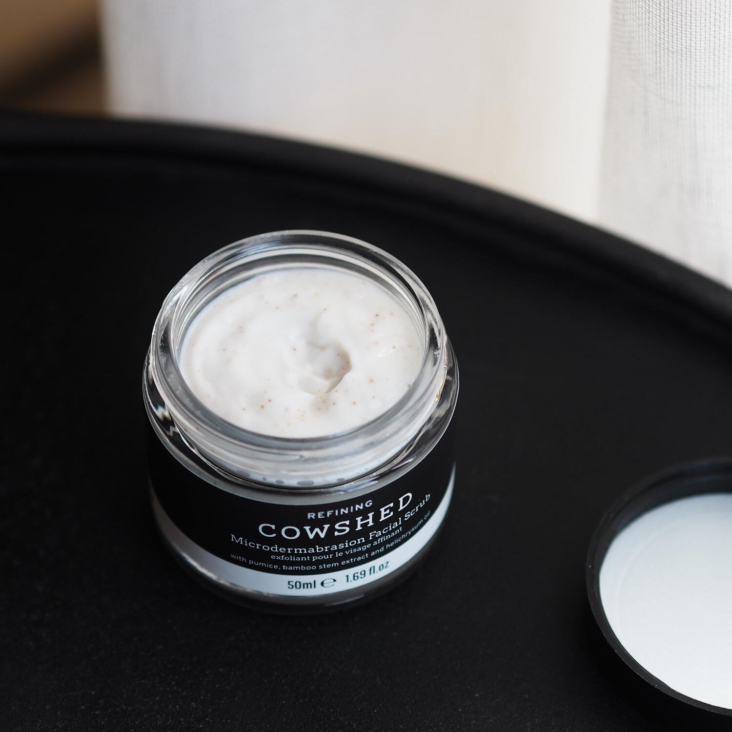 Cowshed skincare product on a black tray with a white background