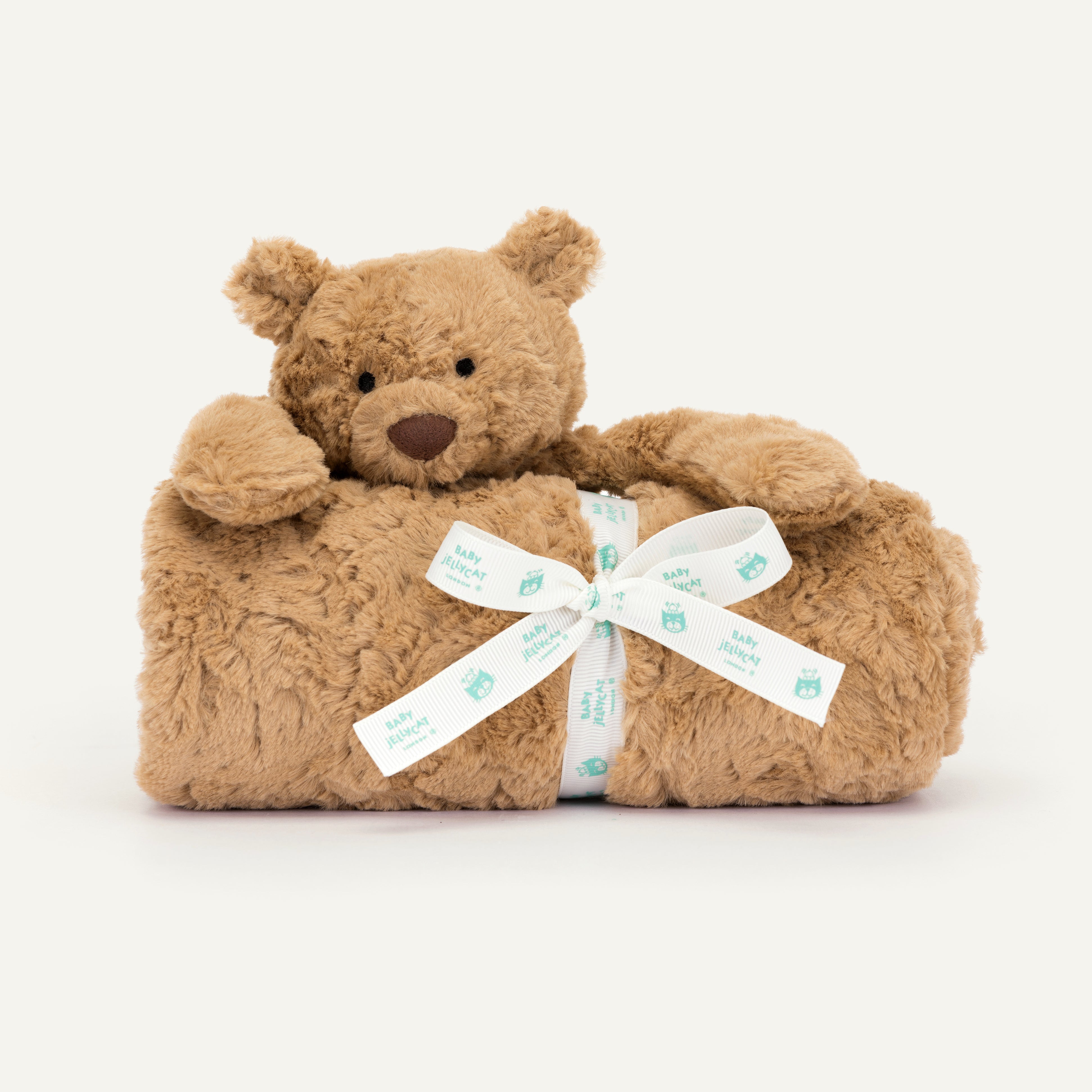 Brown teddy bear with a white blanket and bow on a white background